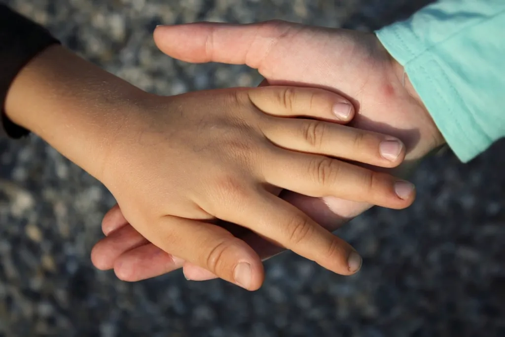 A child’s hand resting in an adult’s hand